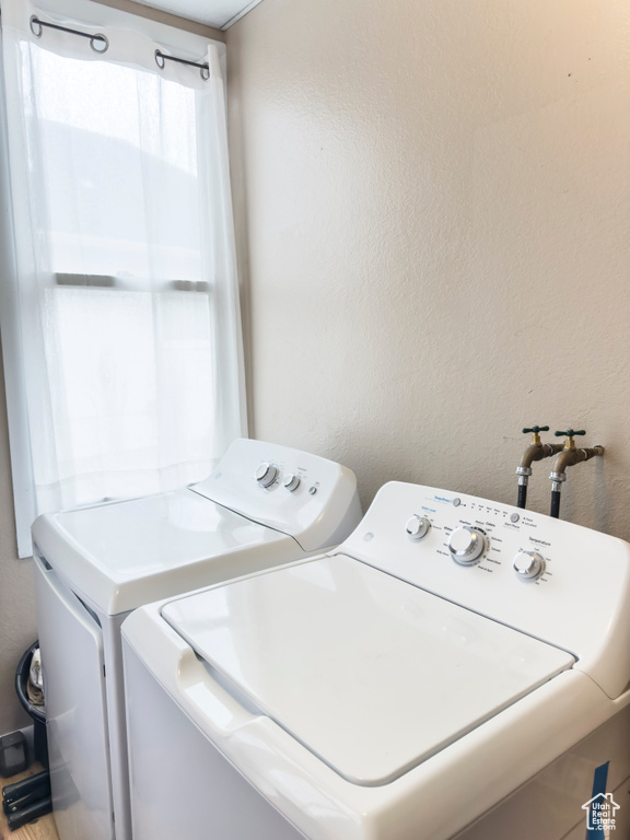 Washroom featuring independent washer and dryer and a textured wall