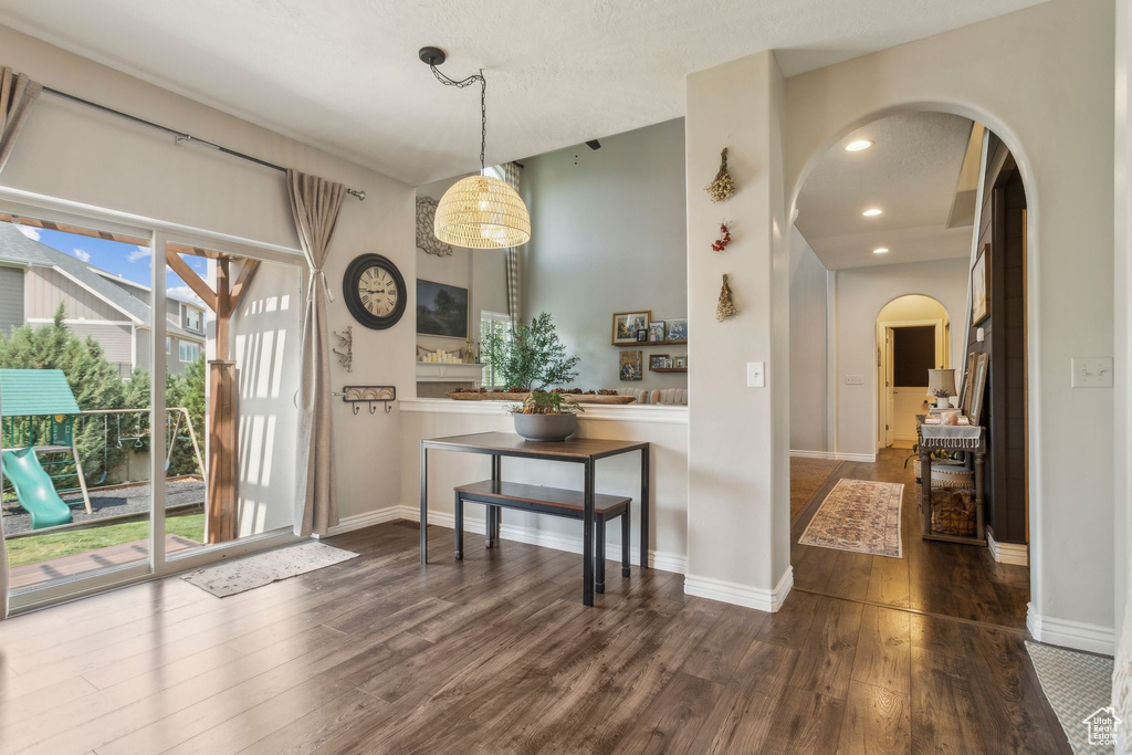 Dining area featuring wood finished floors, baseboards, arched walkways, and recessed lighting