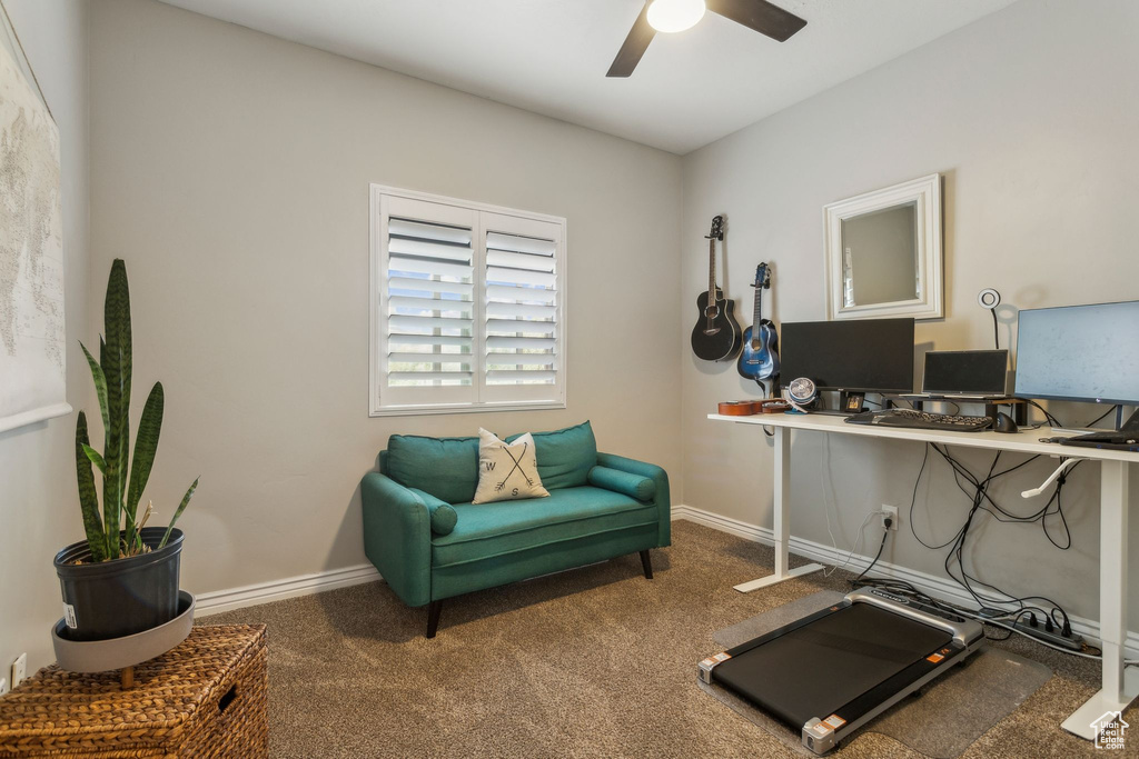 Carpeted office space with ceiling fan and baseboards