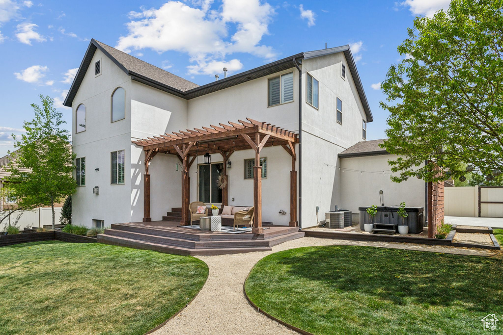 Rear view of property with stucco siding, a pergola, cooling unit, a lawn, and outdoor lounge area
