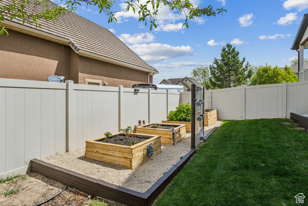 View of yard featuring a vegetable garden and a fenced backyard