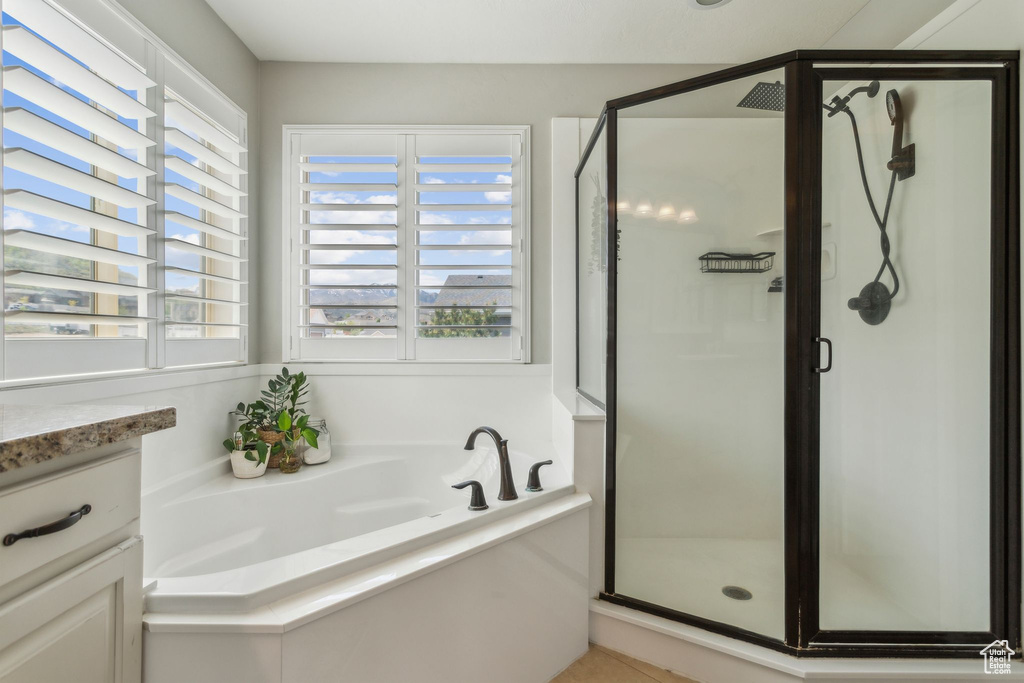 Bathroom with a bath, a shower stall, and plenty of natural light