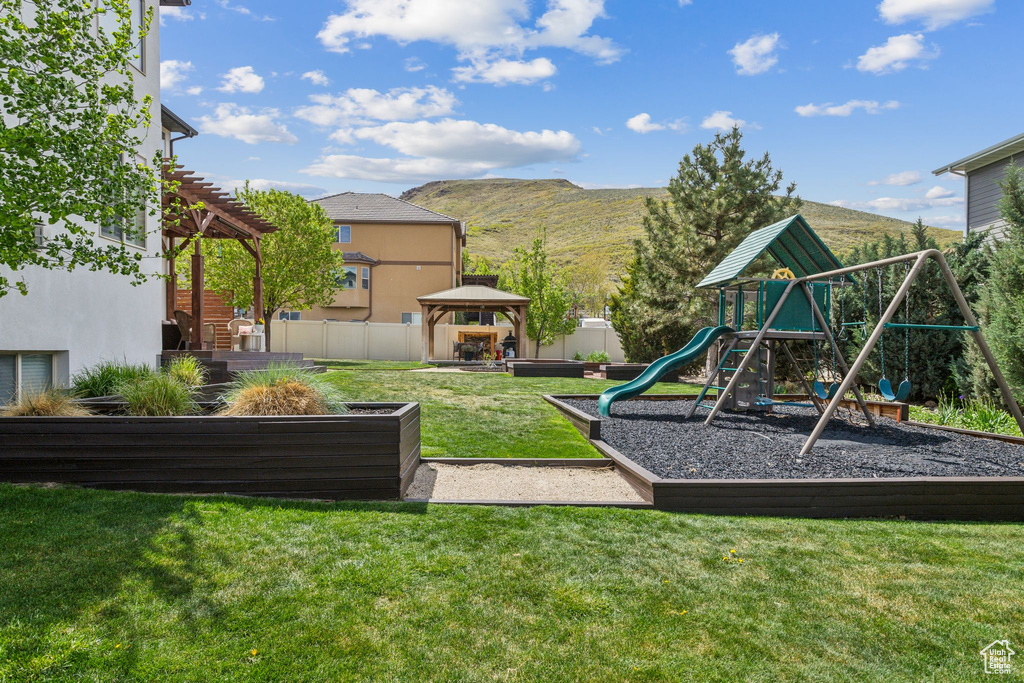 Exterior space featuring a gazebo, a mountain view, and a lawn