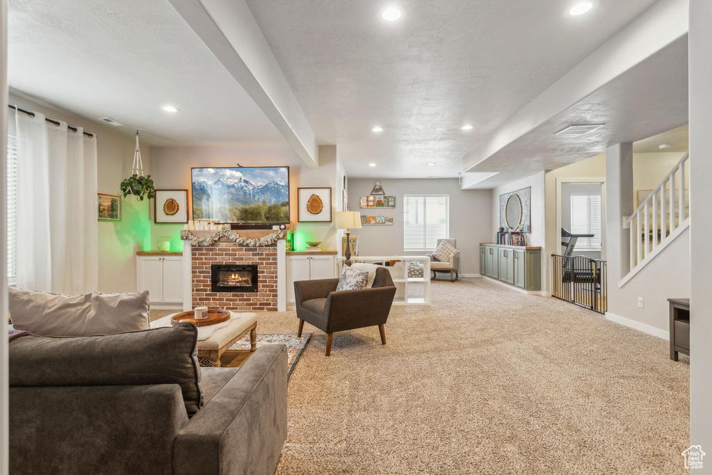 Carpeted living area featuring baseboards, a fireplace, and recessed lighting