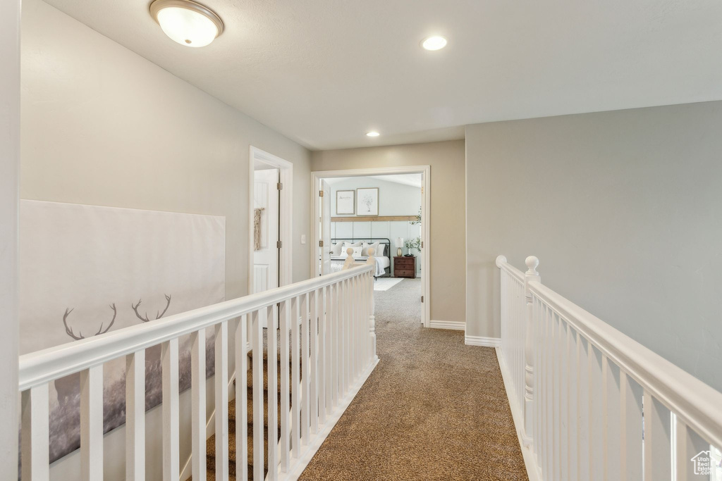 Hallway featuring carpet flooring, an upstairs landing, baseboards, and recessed lighting