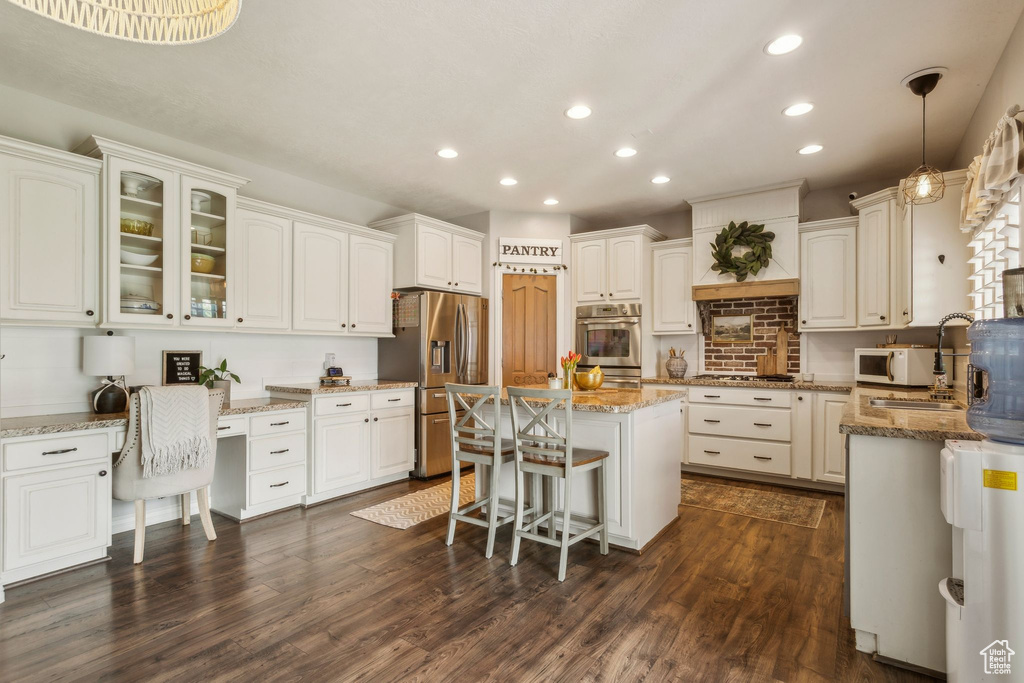 Kitchen featuring stainless steel appliances, white cabinetry, a center island, and recessed lighting