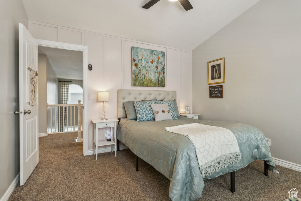 Carpeted bedroom featuring lofted ceiling, baseboards, and ceiling fan