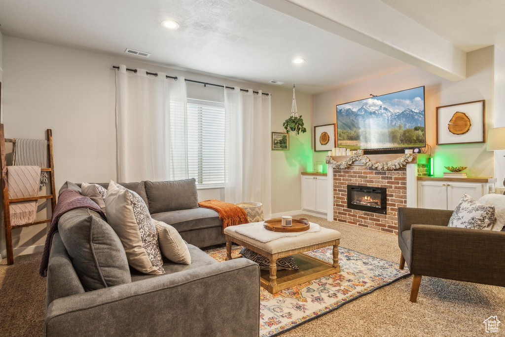 Living area featuring recessed lighting, a brick fireplace, visible vents, and carpet