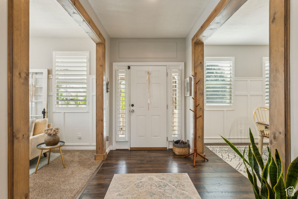 Foyer entrance featuring a decorative wall and dark wood-style floors