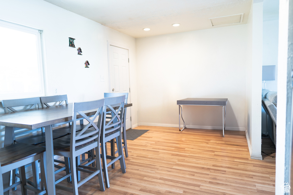 Dining space featuring light wood finished floors, baseboards, and recessed lighting