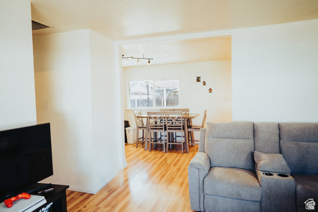 Living area with visible vents and wood finished floors