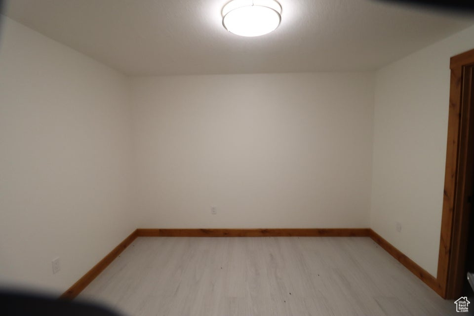 Empty room featuring baseboards and light wood-style floors