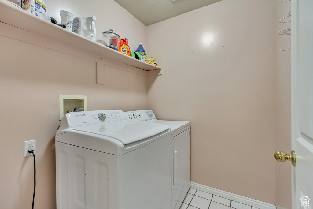 Washroom with washing machine and clothes dryer, laundry area, and light tile patterned floors
