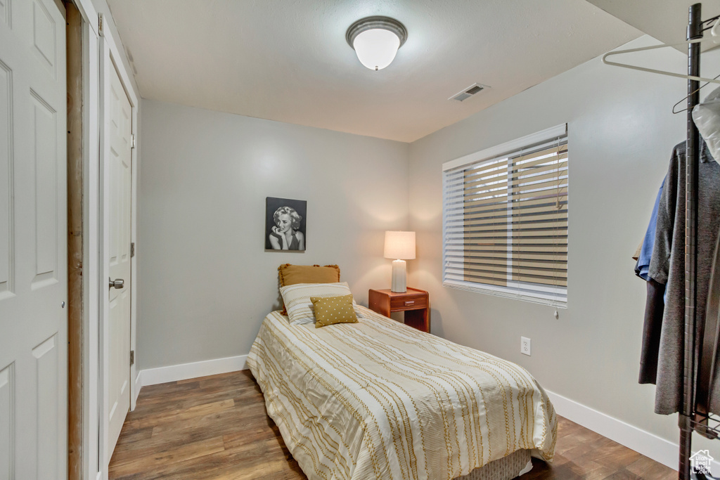 Bedroom featuring visible vents, baseboards, and wood finished floors