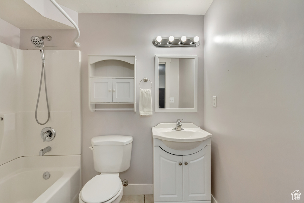 Full bath with vanity, toilet, tile patterned floors, baseboards, and tub / shower combination