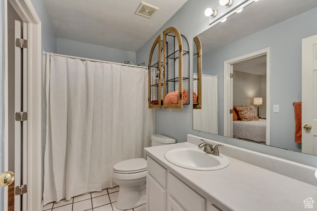 Bathroom featuring visible vents, vanity, curtained shower, toilet, and tile patterned floors