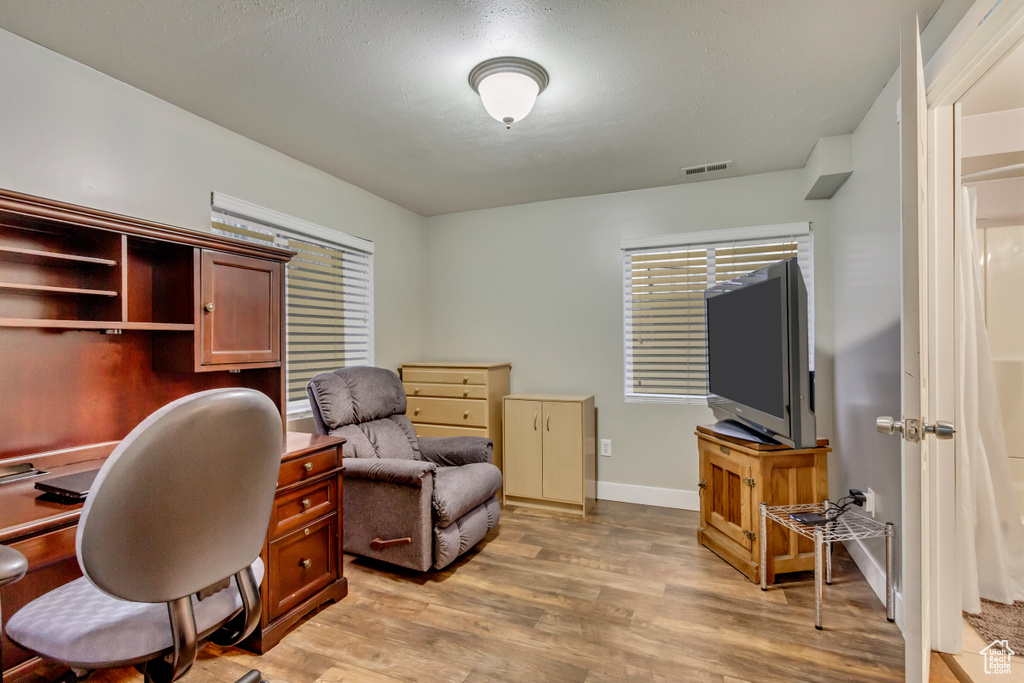 Office featuring visible vents, light wood-style flooring, and baseboards