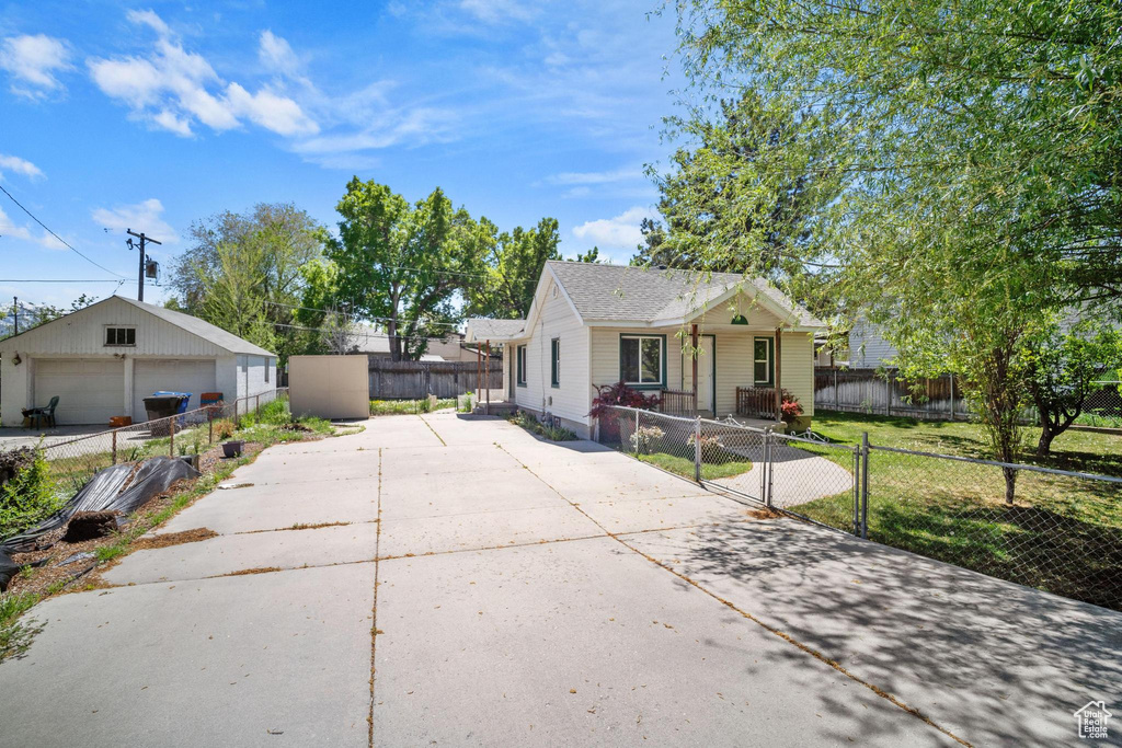 Bungalow with a front yard, a garage, fence private yard, and a gate