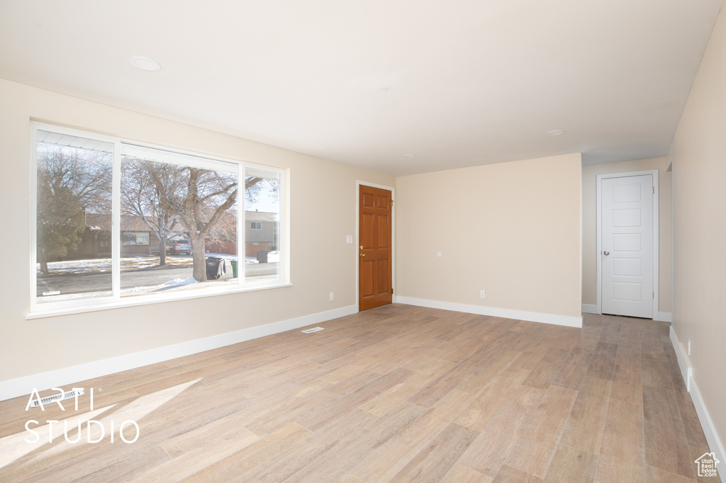 Empty room with baseboards and light wood finished floors