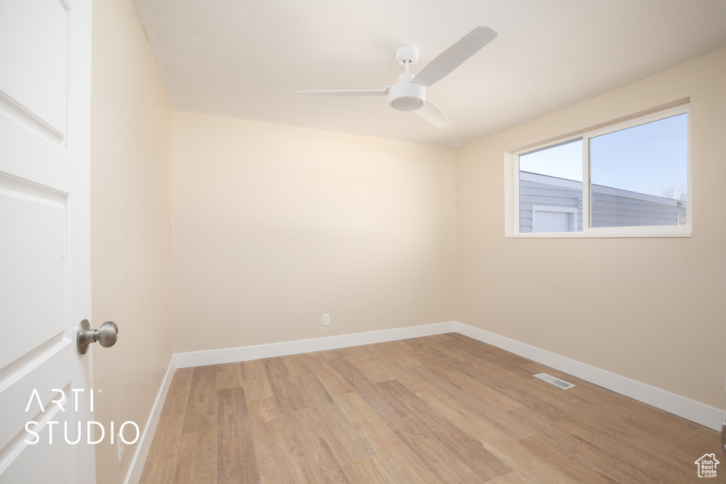 Spare room featuring light wood finished floors, baseboards, a ceiling fan, and visible vents