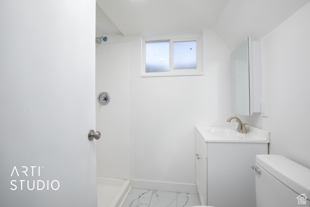 Bathroom with walk in shower, toilet, marble finish floor, vanity, and baseboards