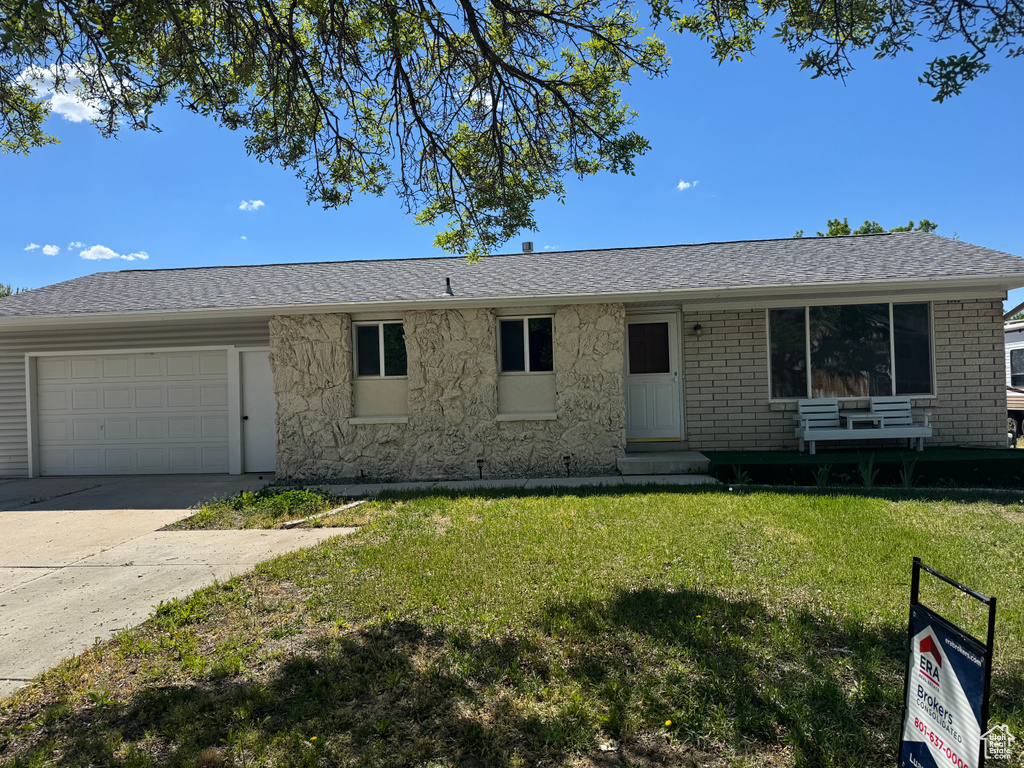 Ranch-style house featuring an attached garage, a front lawn, driveway, entry steps, and roof with shingles