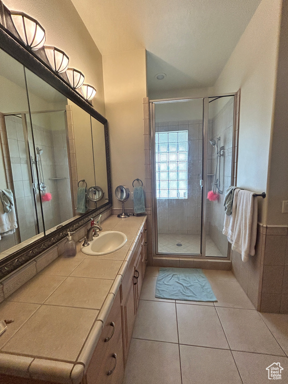 Full bath with a shower stall, tile patterned flooring, and vanity