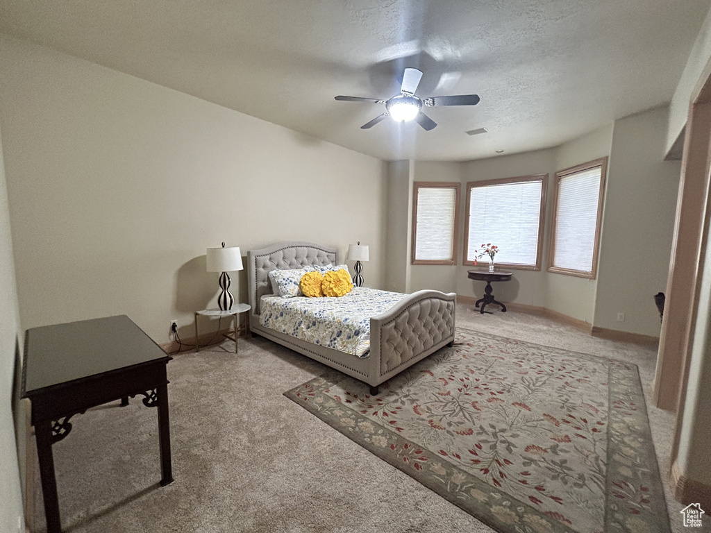 Bedroom with visible vents, baseboards, ceiling fan, and carpet floors