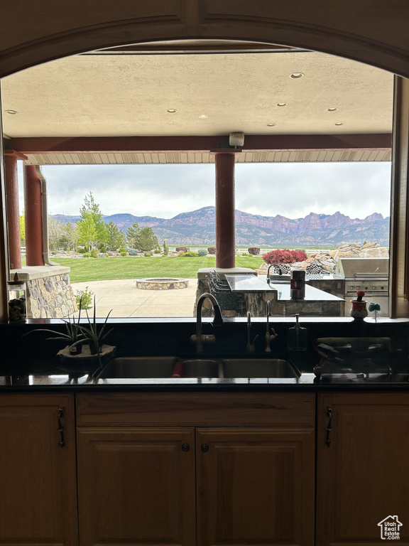 Kitchen with a sink, dark countertops, and a mountain view
