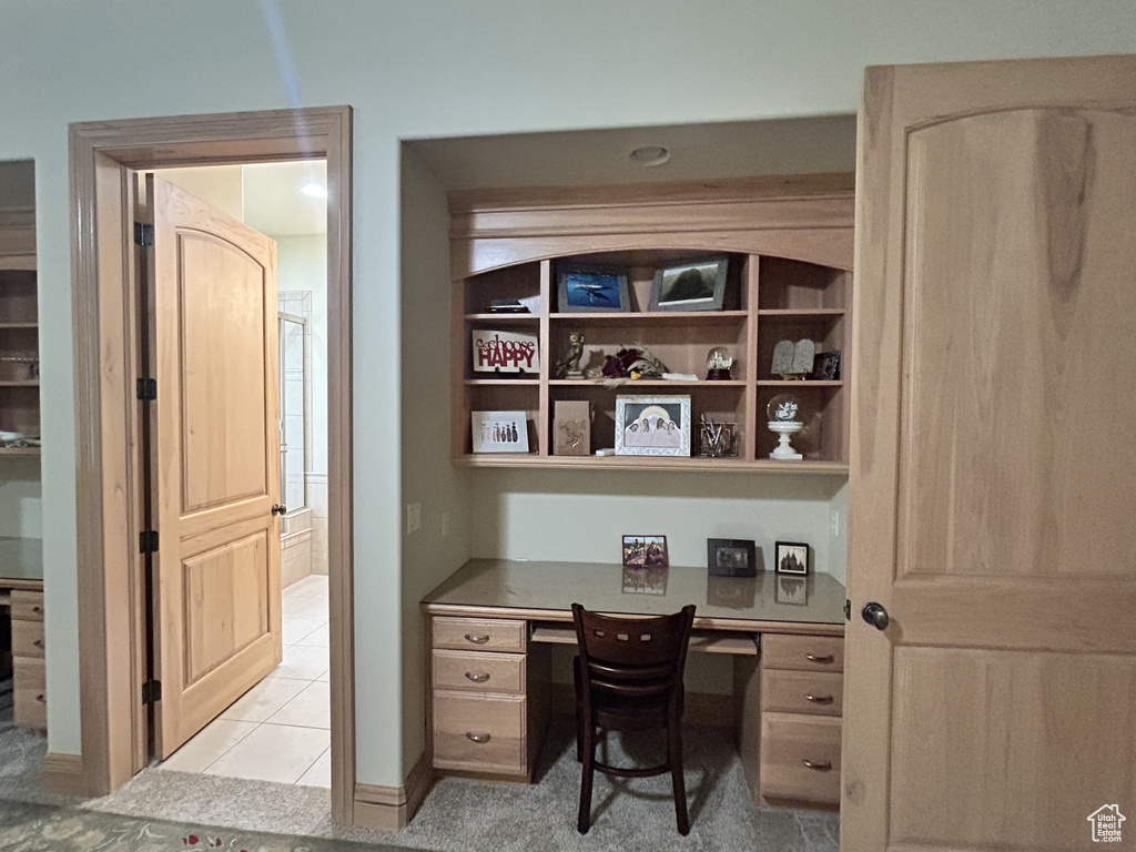 Home office featuring light tile patterned floors and built in study area