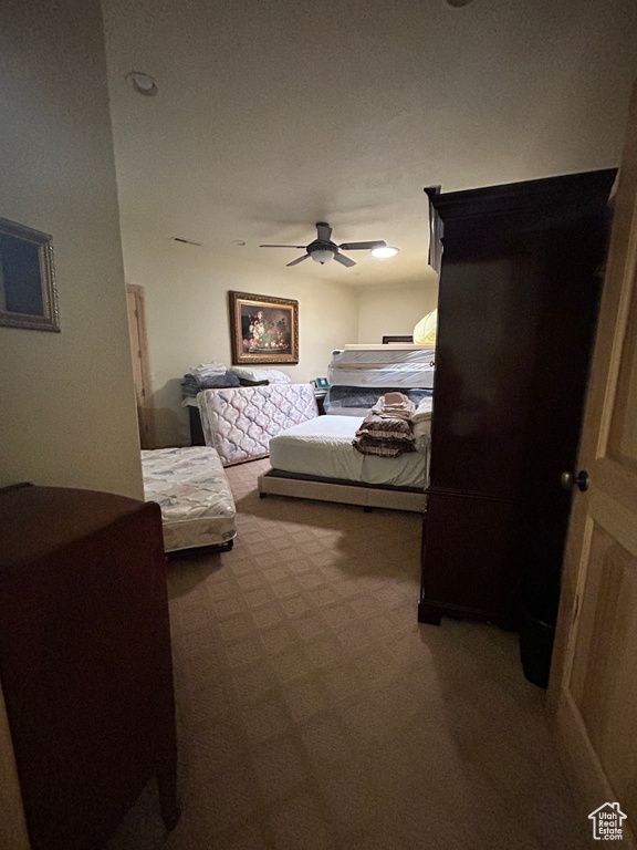 Carpeted bedroom featuring a ceiling fan