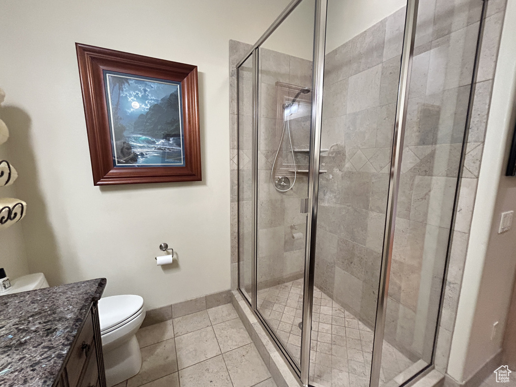 Bathroom with vanity, toilet, baseboards, and a stall shower