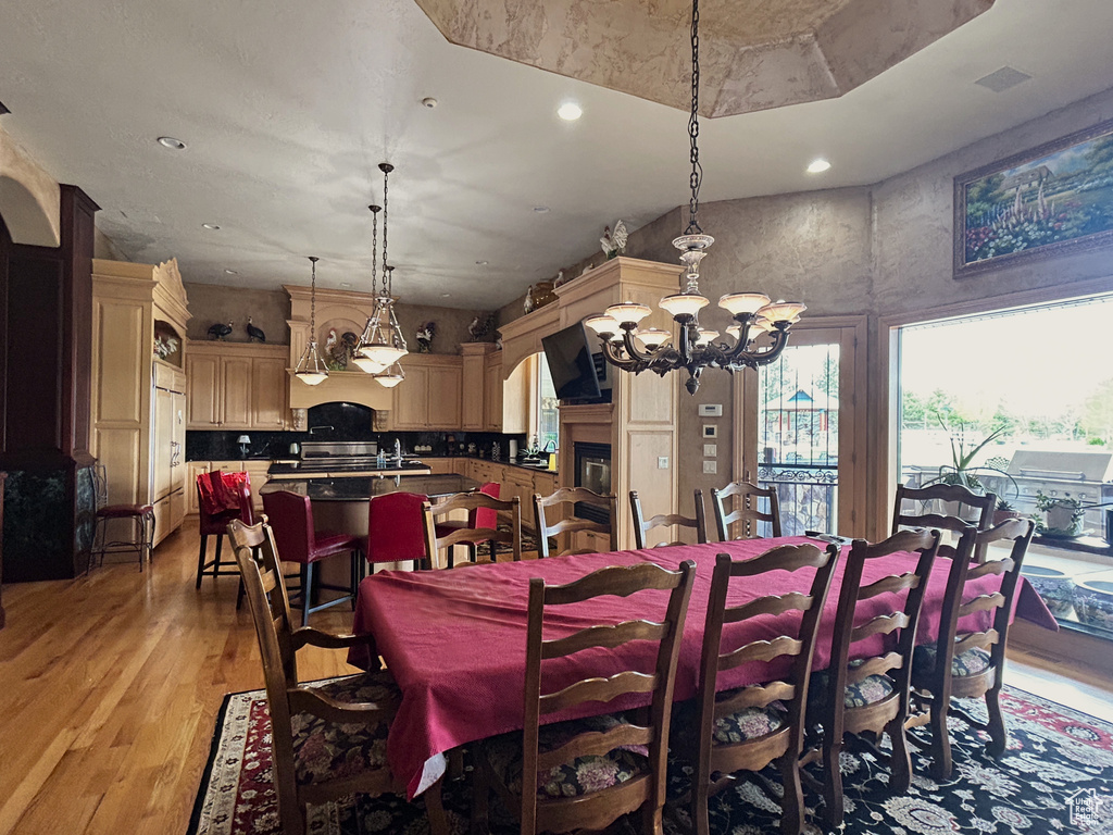 Dining area featuring recessed lighting, light wood-style floors, and a notable chandelier