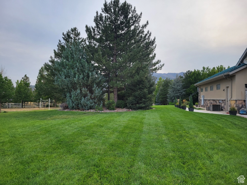 View of yard featuring a mountain view and fence