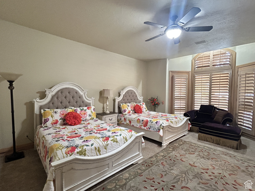 Carpeted bedroom with baseboards and a ceiling fan