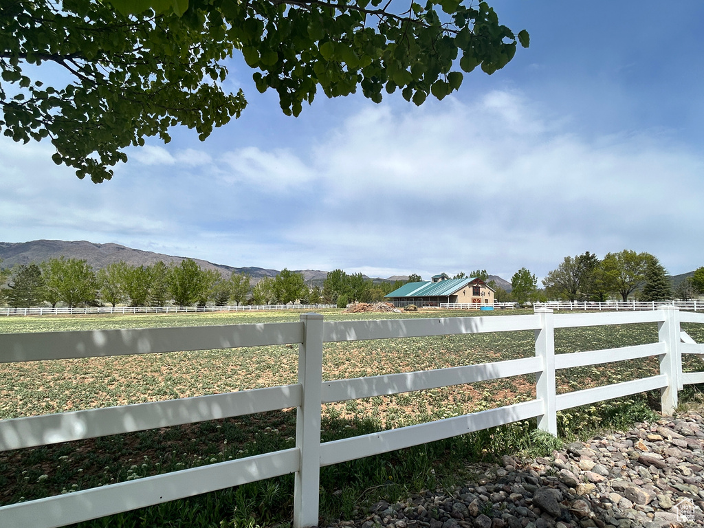 View of yard featuring a rural view, a mountain view, and fence