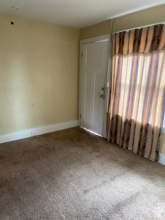 Spare room with baseboards and carpet floors