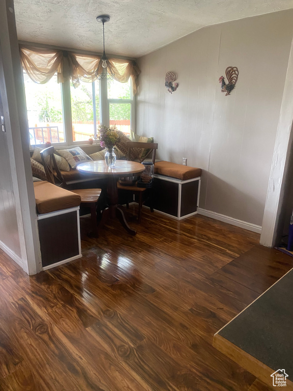 Dining area featuring a textured ceiling, wood finished floors, and baseboards