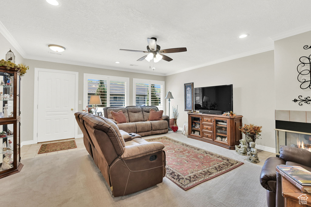 Living room featuring ceiling fan, a fireplace, recessed lighting, baseboards, and ornamental molding