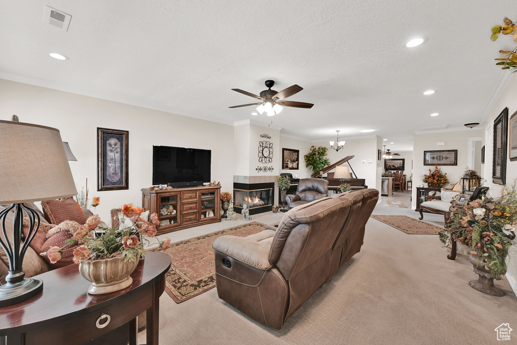 Living room featuring a fireplace, recessed lighting, light carpet, a ceiling fan, and ornamental molding