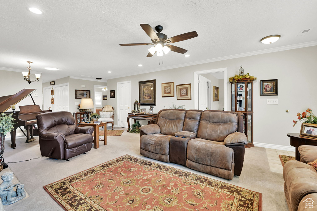 Living room featuring light carpet, a ceiling fan, a chandelier, recessed lighting, and crown molding