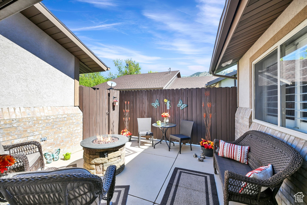 View of patio / terrace with fence and an outdoor living space with a fire pit