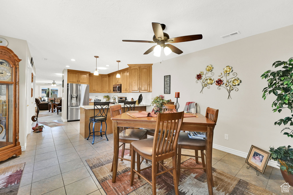 Dining space featuring ceiling fan, light tile patterned flooring, recessed lighting, and baseboards