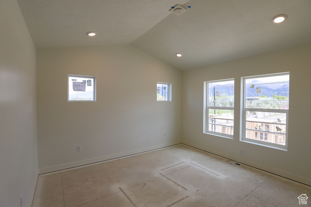 Empty room with baseboards, recessed lighting, visible vents, and vaulted ceiling
