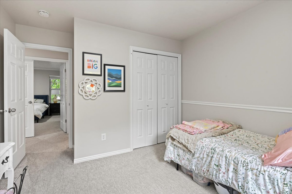 Carpeted bedroom with a closet and baseboards