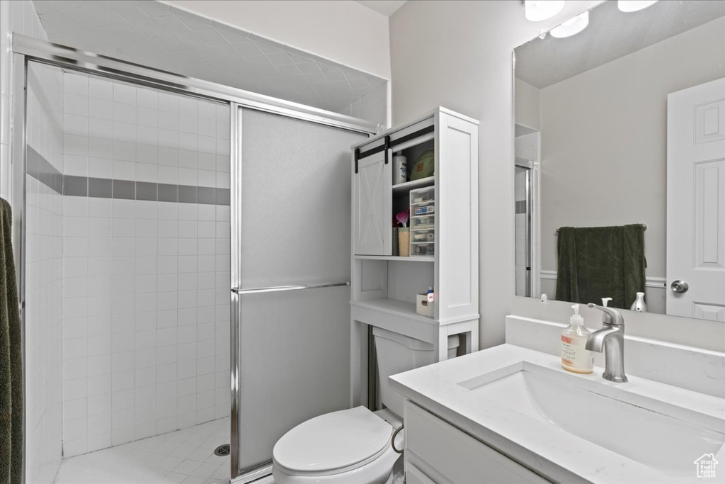 Bathroom with a shower stall, vanity, and toilet