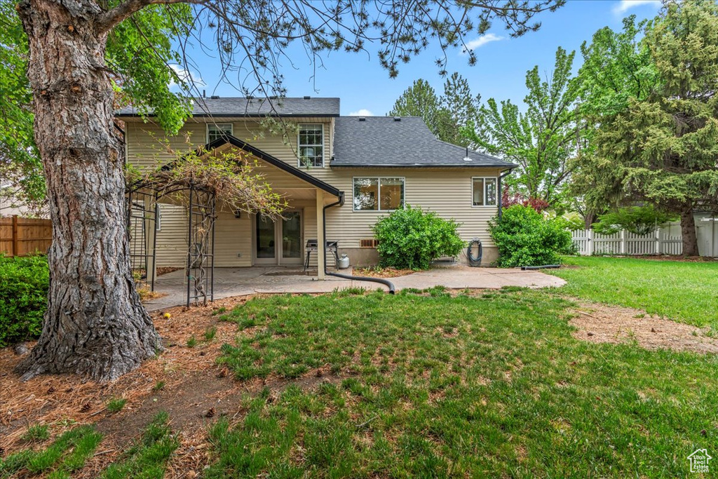 Back of house featuring a yard, a patio area, and fence