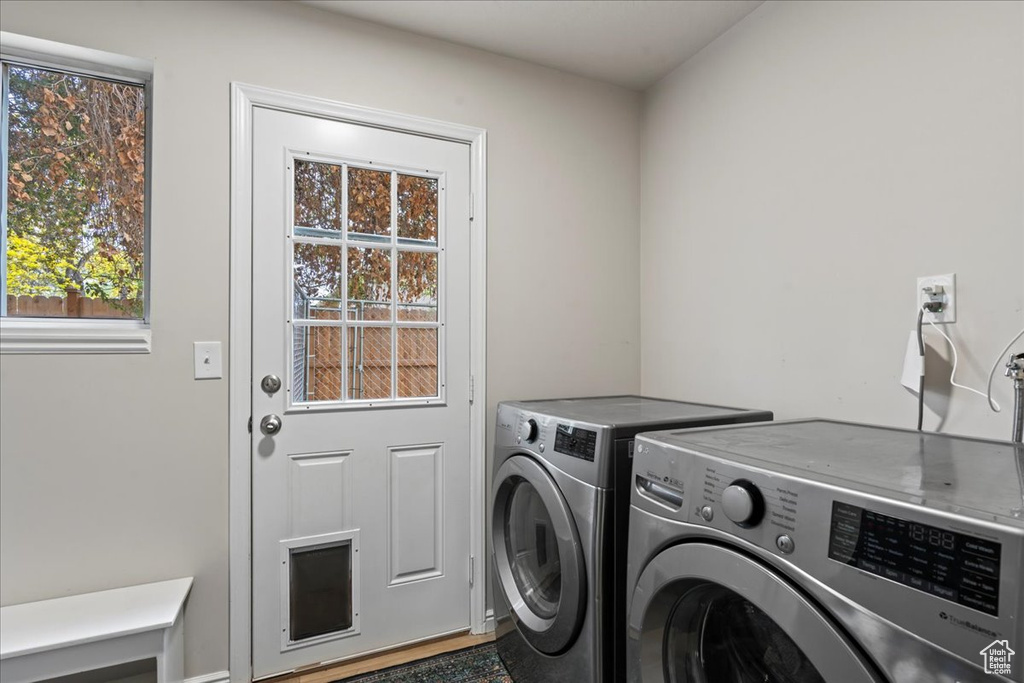 Clothes washing area with washer and clothes dryer, laundry area, and a wealth of natural light