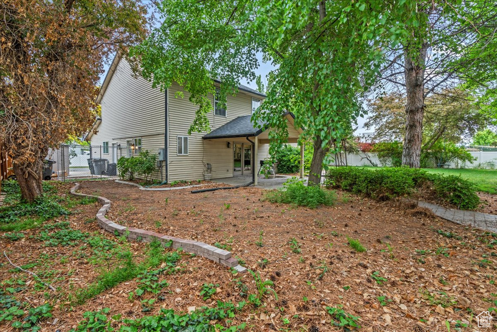 Exterior space with a gate, fence, and a patio