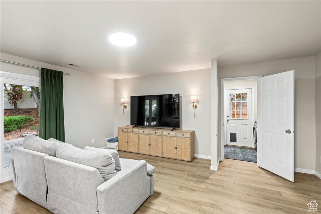 Living room with baseboards, light wood-style floors, and visible vents